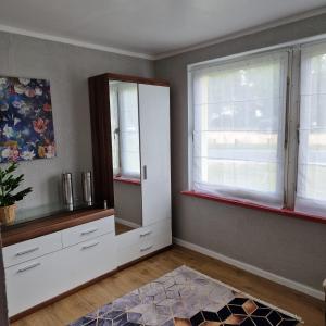 a living room with white cabinets and windows at Rema Ferienwohnungen in Zossen