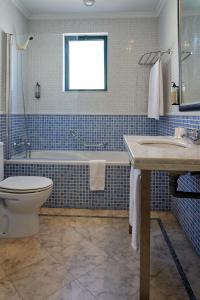 a bathroom with a toilet and a tub and a sink at The Navigator - Palm Oasis Alvor - All Inclusive in Alvor