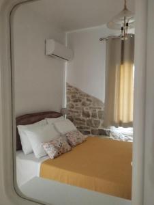 a bedroom with a bed with a mirror on it at Το Πέτρινο in Aitolikón