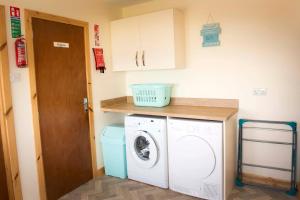 a small laundry room with a washer and dryer at Seafront holiday home in Findochty in Findochty