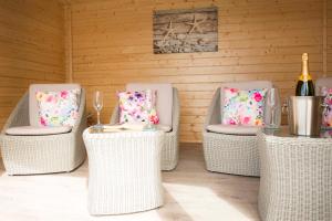 un grupo de sillas de mimbre y una mesa con una botella de vino en Seafront holiday home in Findochty, en Findochty