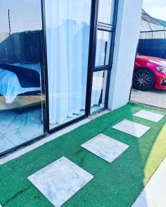 a green floor with three tiles on it next to a window at The Pool_deck apartment in Lebowakgomo