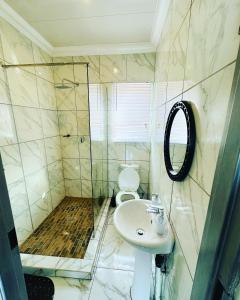 La salle de bains est pourvue de toilettes, d'un lavabo et d'une douche. dans l'établissement The Pool_deck apartment, à Lebowakgomo