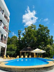 uma grande piscina azul com um guarda-sol e cadeiras em Vita Gardenia Hotel Tskaltubo em Tskaltubo