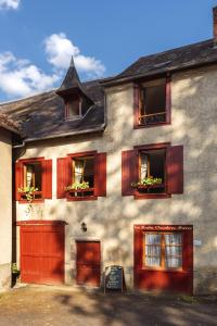 Casa grande con puertas y ventanas rojas en La Ruche Chambres d'hôtes, en Ségur-le-Château