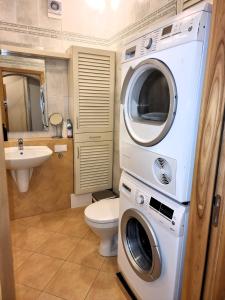 a bathroom with a washing machine and a toilet at Great View Meridianas Apartment in Klaipėda