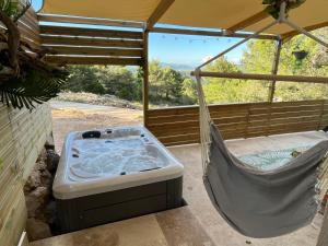 a hot tub in a hammock on a porch at Le Maquis Rooms in Plan dʼAups +1 photo