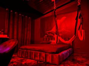 a red room with a bed with a swing at Le Maquis Rooms in Plan dʼAups