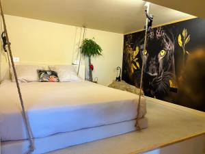 a bedroom with a swinging bed with a painting on the wall at Le Maquis Rooms in Plan dʼAups