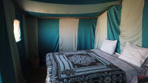 a bedroom with a bed with a canopy at Camp Desert Trips in Mhamid