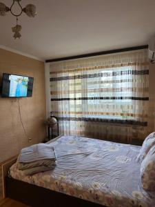 a bedroom with a bed and a tv on the wall at Квартира з видом на Дніпро in Cherkasy