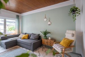 a living room with a couch and a chair at Wohlfühlwohnung mit 25 qm Terrasse, Netflix in Koblenz