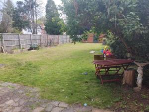 a picnic table under a tree in a yard at Room in private house near Reading University in Earley