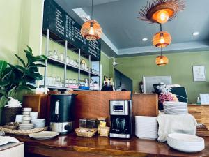 a kitchen with a counter with plates and a coffee shop at Field-D House in Koh Tao