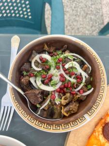 a bowl of food with vegetables and onions on a table at Inn David in Chakvi