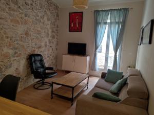 ein Wohnzimmer mit einem Sofa und einem Stuhl in der Unterkunft Location appartement T3 à Sète in Sète
