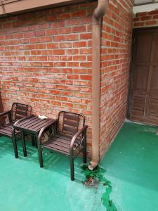 a patio with a table and chairs next to a brick wall at RANGOON RESIDENCES + in George Town