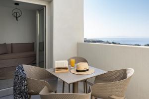 a table with two sandwiches and a hat on a balcony at Alegria by Casa Sigalas in Oia