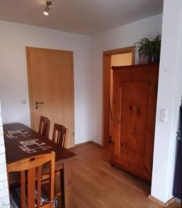 a dining room with a table and chairs and a door at Bernsteinglück in Wunsiedel