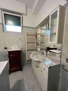 uma casa de banho com um lavatório e um espelho grande em Colibrì, vicino a pineta e mare em Viareggio