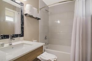 Canadas Best Value Inn & Suites Kamloops في كاملوبس: حمام مع حوض وحوض استحمام ودش