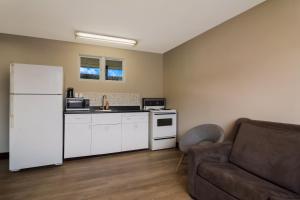 uma cozinha com um frigorífico branco e um sofá em Canadas Best Value Inn & Suites Kamloops em Kamloops
