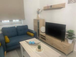 a living room with a blue couch and a flat screen tv at Apartamento en Toledo ideal para visitas a Puy du Fou in Toledo