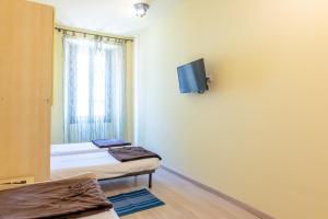 a room with two beds and a tv on the wall at Aosta Centre Apartments - Porta Pretoria 56 in Aosta