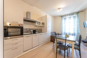 a kitchen with a table and a dining room at Aosta Centre Apartments - Porta Pretoria 56 in Aosta
