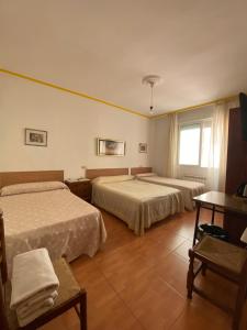 a hotel room with two beds and a window at PENSIÓN SANTA CLARA in Pontevedra