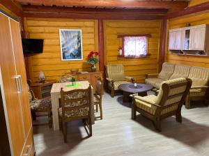 - un salon avec un canapé, des chaises et une table dans l'établissement R&S Domki, à Darłowo