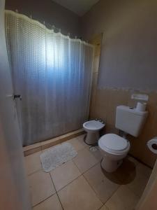 a bathroom with a toilet and a shower at Los Bambues Cabañas in El Volcán