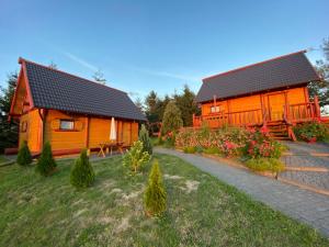 a log cabin with a pathway next to a house at R&S Domki in Darłowo