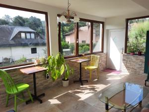 a patio with two tables and chairs and windows at Erholungsheim im Wienerwald in Irenental