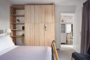 a bedroom with a bed and a wooden cabinet at K Waterfront Residence In Mani in Áyios Kiprianós
