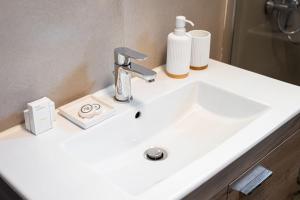 a white bathroom sink with a faucet on it at K Waterfront Residence In Mani in Áyios Kiprianós