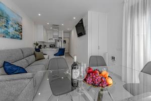 a living room with a glass table with a bowl of fruit at Luxury 2bedroom apartment on San Juan Beach in Playa de San Juan