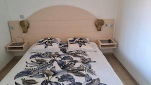 a bedroom with a bed with a flowery bedspread at studio plage de l'anse caritan in Sainte-Anne