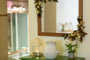 uma mesa de casa de banho com um vaso e um espelho em Il Pozzo em San Gimignano