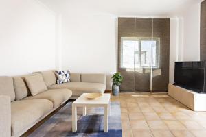 un soggiorno con un divano e una TV di Cabanas Terrace a Cabanas de Tavira