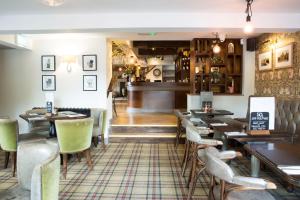 un restaurante con mesas y sillas y un bar en Alvanley Arms, Cotebrook en Tarporley