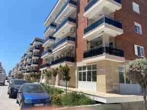 a building with cars parked in front of it at Apartment Ferizaj in Velipojë