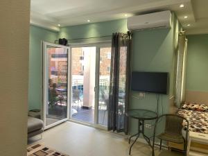 a living room with a tv and a couch and a table at Apartment Ferizaj in Velipojë