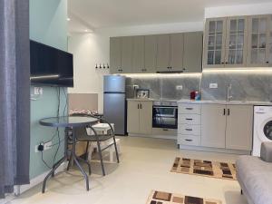 a kitchen with a table and a refrigerator at Apartment Ferizaj in Velipojë