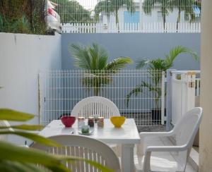 una mesa blanca y sillas con cuencos en Rubis Appartement - Magnifique F3, en Sainte-Anne