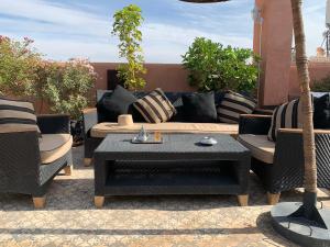 a patio with a couch and chairs and a table at Palais Aix Kabaj &Spa in Marrakech