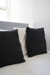 zwei schwarze Kissen auf dem Bett in der Unterkunft Douglas Manor in Douglas