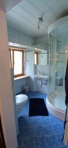 ein Badezimmer mit einer Badewanne, einem WC und einem Waschbecken in der Unterkunft Gasthof Zum Lugauer in Radmer an der Hasel