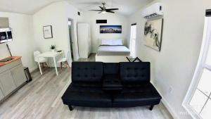 布蘭登的住宿－All modern Studio with private entry & parking.，一间带黑色沙发的客厅和一间卧室