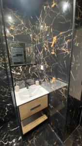 a bathroom with a sink and a black marble wall at * 3 Chambres - Haut de gamme - proche Paris * in Villejuif